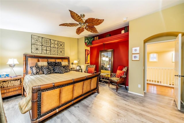 bedroom featuring wood finished floors, a ceiling fan, and baseboards