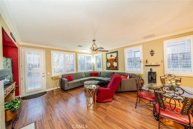 living area with ornamental molding, plenty of natural light, and wood finished floors