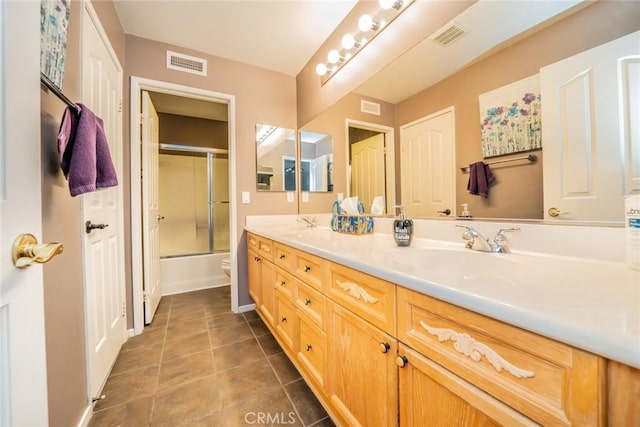 bathroom featuring double vanity, tile patterned flooring, visible vents, and a sink