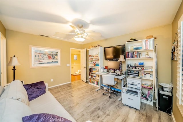 office area with a ceiling fan, wood finished floors, visible vents, and baseboards