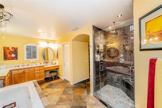 full bath featuring double vanity, visible vents, stone finish flooring, a shower stall, and baseboards