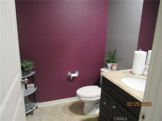 bathroom with baseboards, toilet, and vanity