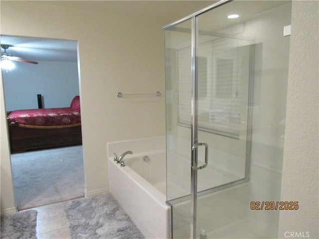 bathroom with a ceiling fan, ensuite bath, a stall shower, tile patterned flooring, and a bath