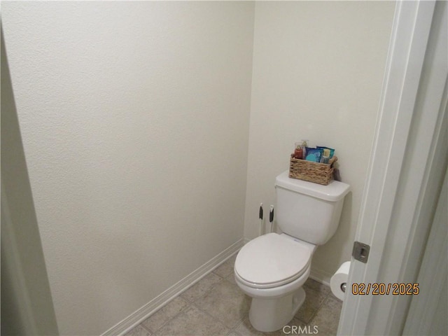 bathroom featuring tile patterned floors, toilet, and baseboards