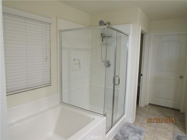 full bath featuring a garden tub, a stall shower, and tile patterned flooring