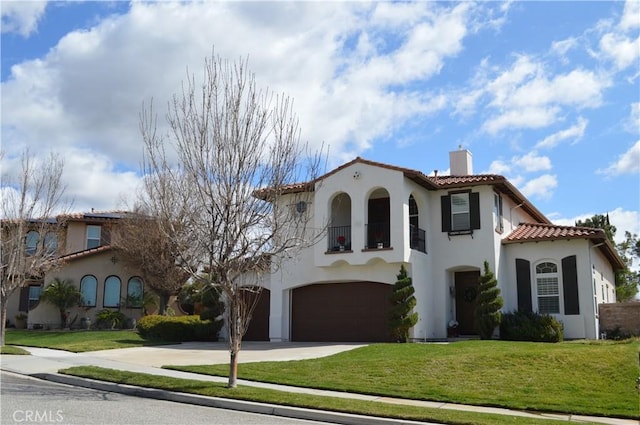 mediterranean / spanish house featuring a garage, a tile roof, stucco siding, a front lawn, and a chimney