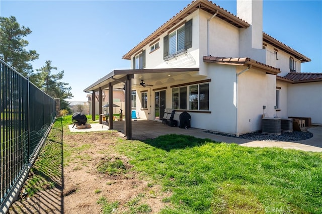 back of house featuring a patio, a chimney, stucco siding, ceiling fan, and a fenced backyard