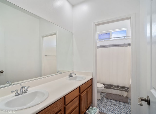 bathroom with double vanity, a shower with shower curtain, a sink, and toilet