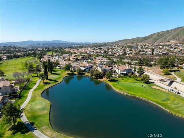 drone / aerial view featuring view of golf course, a residential view, and a water and mountain view