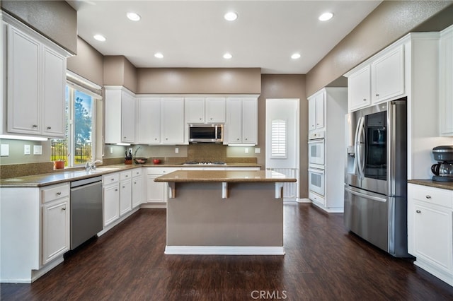 kitchen with white cabinetry, stainless steel appliances, and dark wood finished floors