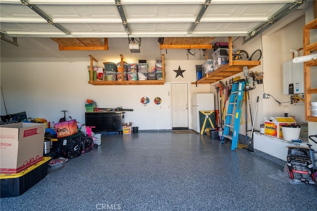 garage featuring water heater and freestanding refrigerator