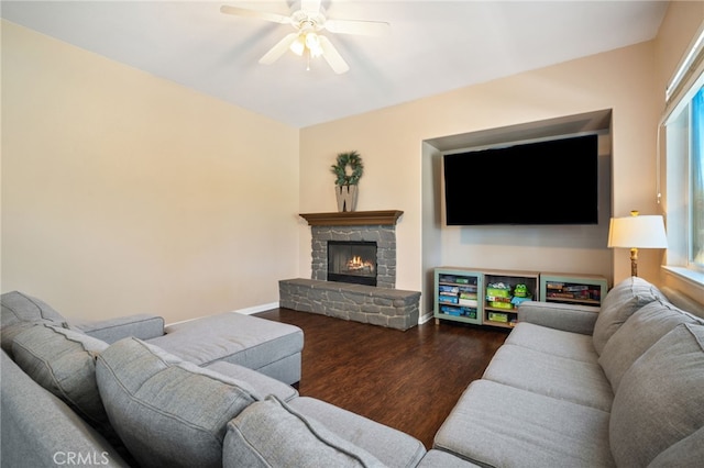 living room featuring a ceiling fan, a healthy amount of sunlight, a fireplace, and wood finished floors