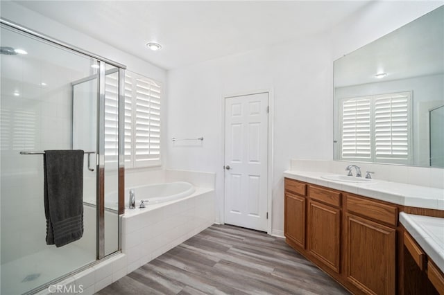 full bath with a garden tub, a shower stall, wood finished floors, and vanity