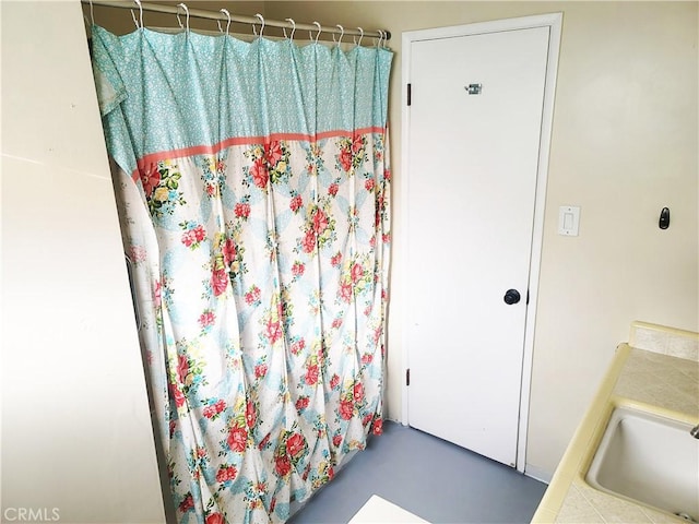 full bathroom featuring curtained shower and a sink