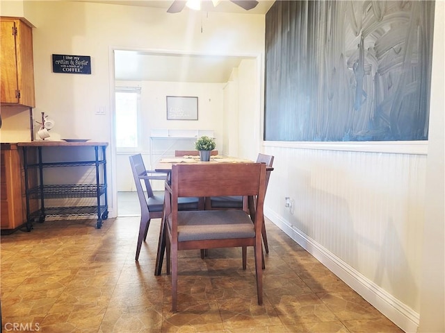 dining space with ceiling fan and baseboards