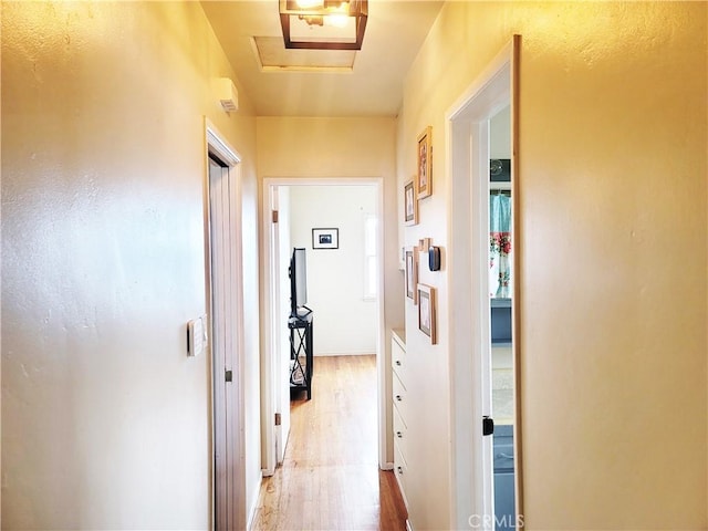 hallway featuring attic access and wood finished floors