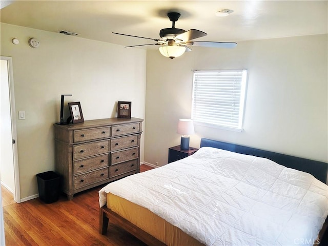 bedroom featuring visible vents, wood finished floors, a ceiling fan, and baseboards