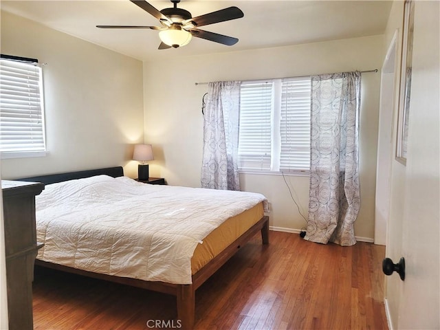 bedroom with a ceiling fan, baseboards, and wood finished floors