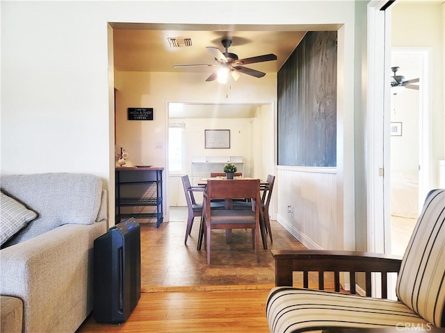 dining space featuring ceiling fan, light wood-type flooring, visible vents, and baseboards