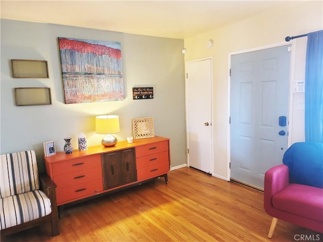 living area with light wood-type flooring and baseboards