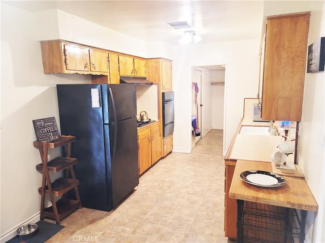 kitchen with black appliances, light countertops, and baseboards