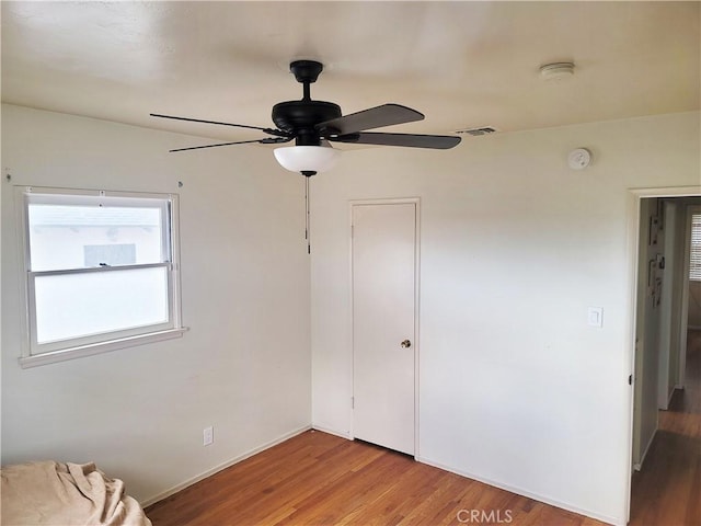 unfurnished bedroom with light wood finished floors, a ceiling fan, visible vents, and a closet