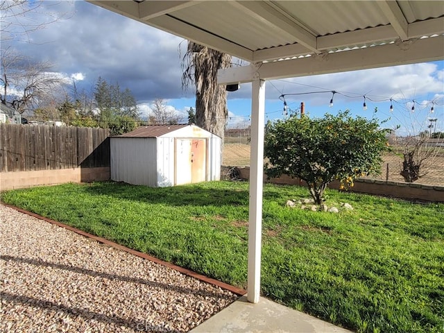 view of yard featuring a fenced backyard, a storage unit, and an outdoor structure