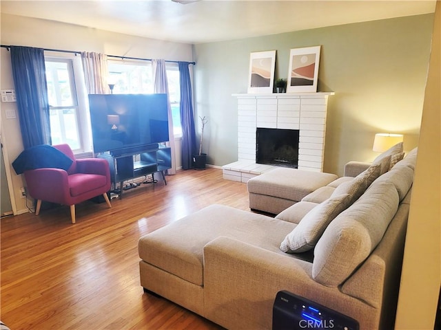 living room with a fireplace, wood finished floors, and baseboards