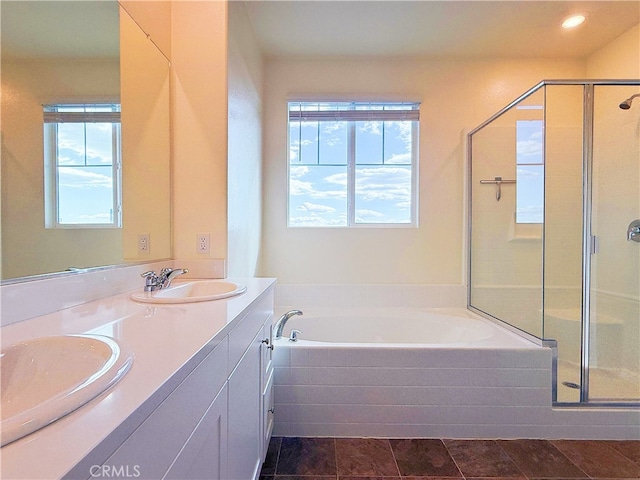 bathroom with a stall shower, a garden tub, a sink, and double vanity