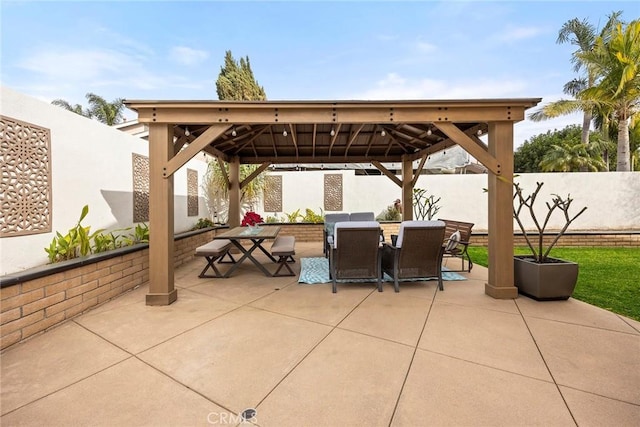 view of patio / terrace with a fenced backyard, an outdoor living space, outdoor dining area, and a gazebo