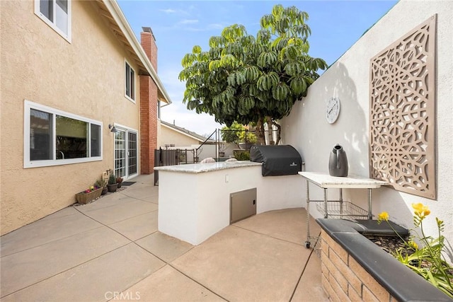 view of patio / terrace featuring area for grilling, fence, and an outdoor kitchen