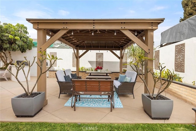 view of patio with a gazebo, outdoor dining area, and fence