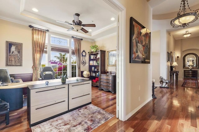 home office featuring baseboards, ceiling fan, ornamental molding, dark wood-type flooring, and a raised ceiling