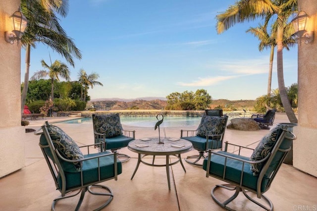 view of patio / terrace featuring an outdoor pool, a mountain view, and an outdoor hangout area