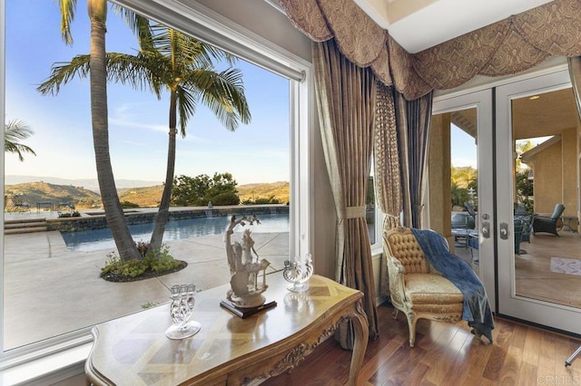 sitting room with a mountain view, french doors, and wood finished floors