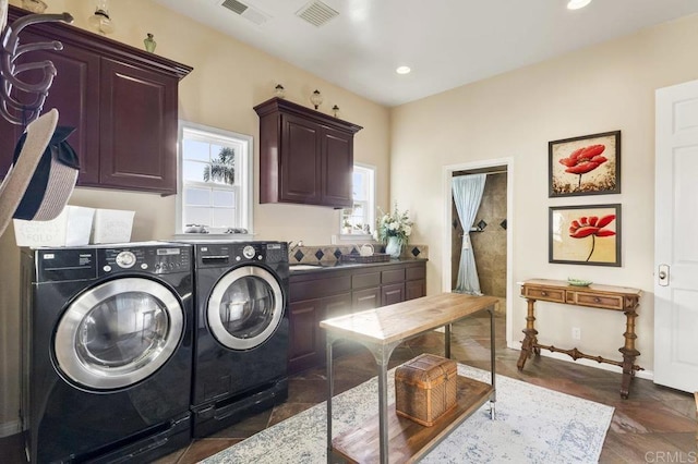 laundry area with cabinet space, recessed lighting, separate washer and dryer, and visible vents