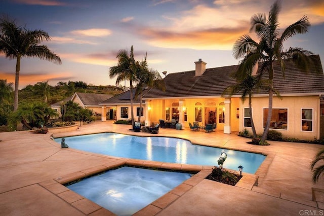 pool featuring an in ground hot tub and a patio