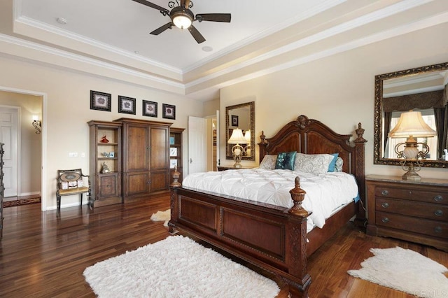 bedroom with a tray ceiling, dark wood-style floors, baseboards, and ornamental molding