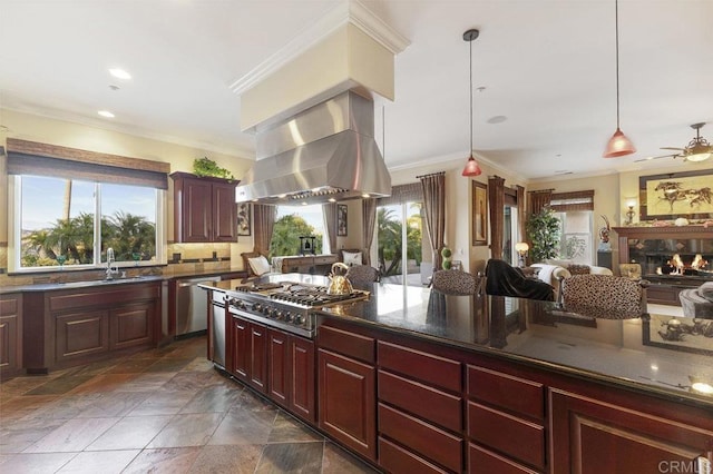 kitchen featuring a sink, appliances with stainless steel finishes, open floor plan, a wealth of natural light, and island range hood