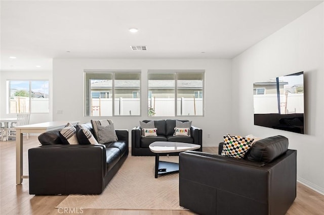 living room featuring baseboards, light wood finished floors, visible vents, and recessed lighting