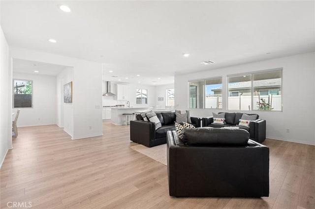 living room featuring a healthy amount of sunlight, light wood-style floors, and recessed lighting