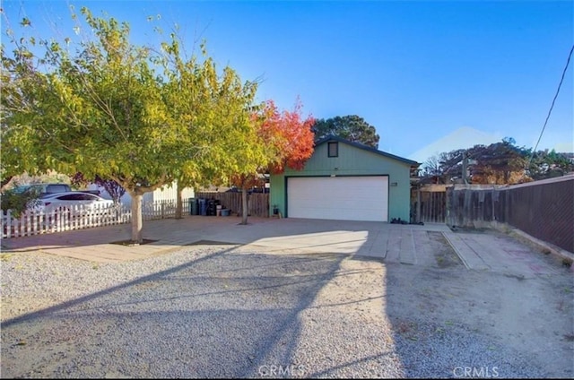 view of front of house with a garage, fence, and an outdoor structure