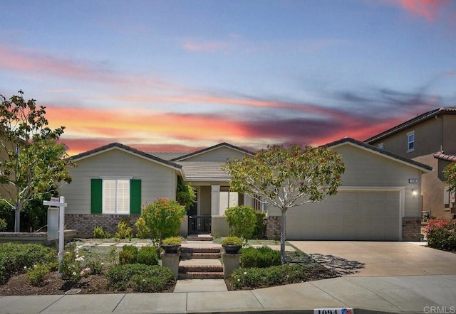 ranch-style home featuring an attached garage, driveway, and brick siding