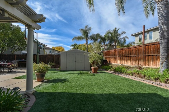 view of yard featuring an outbuilding, a patio area, a storage shed, and a fenced backyard