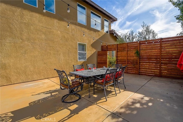 view of patio featuring stairway, outdoor dining space, and fence