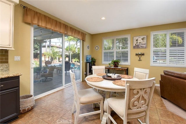 dining room with light tile patterned floors, recessed lighting, and baseboards