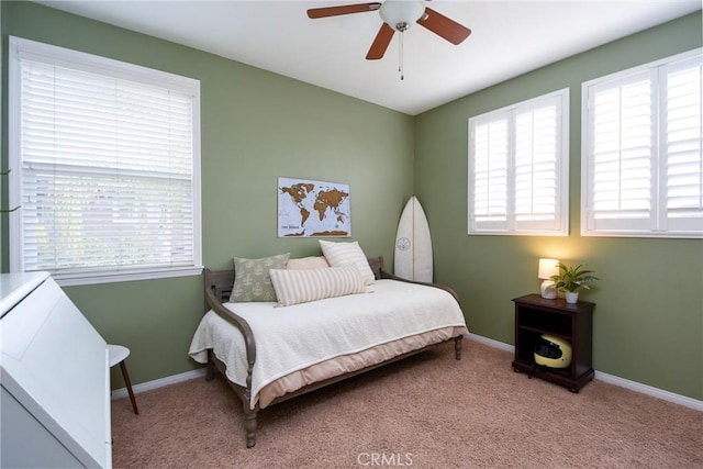 bedroom with a ceiling fan, baseboards, and carpet floors