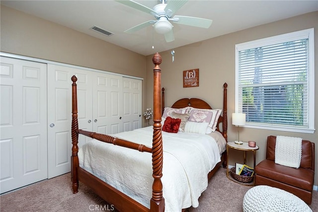 carpeted bedroom featuring visible vents, a closet, and a ceiling fan