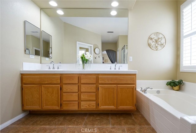 bathroom with a sink, visible vents, a garden tub, and double vanity