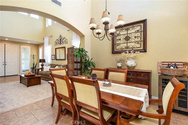 dining room featuring beverage cooler, visible vents, a wealth of natural light, and arched walkways